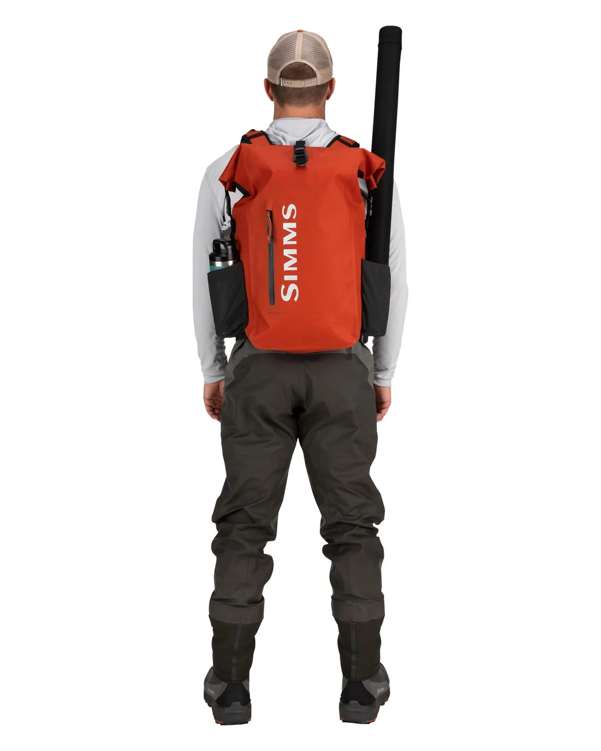 Person wearing a red Simms backpack and waders on a white background