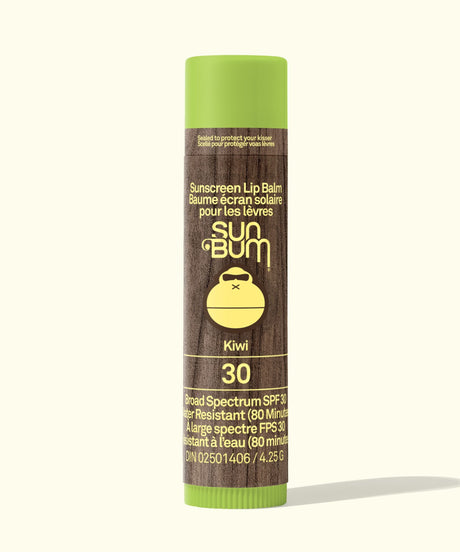 Sun Bum sunscreen lip balm with green cap and brown body on a white background