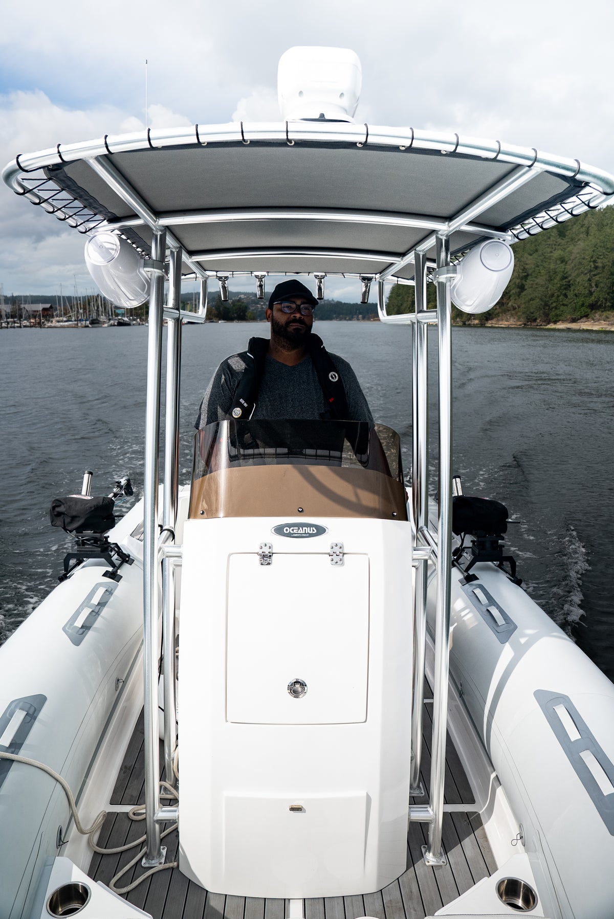 Skipper at the centre console helm under the T-top, seen from the bow while under way