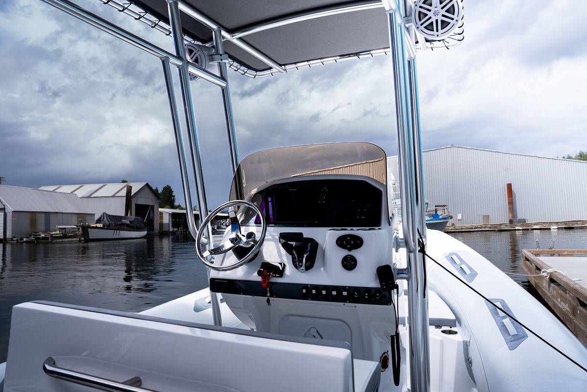 Centre console helm with steering wheel and windscreen under the T-top, seen from the seat