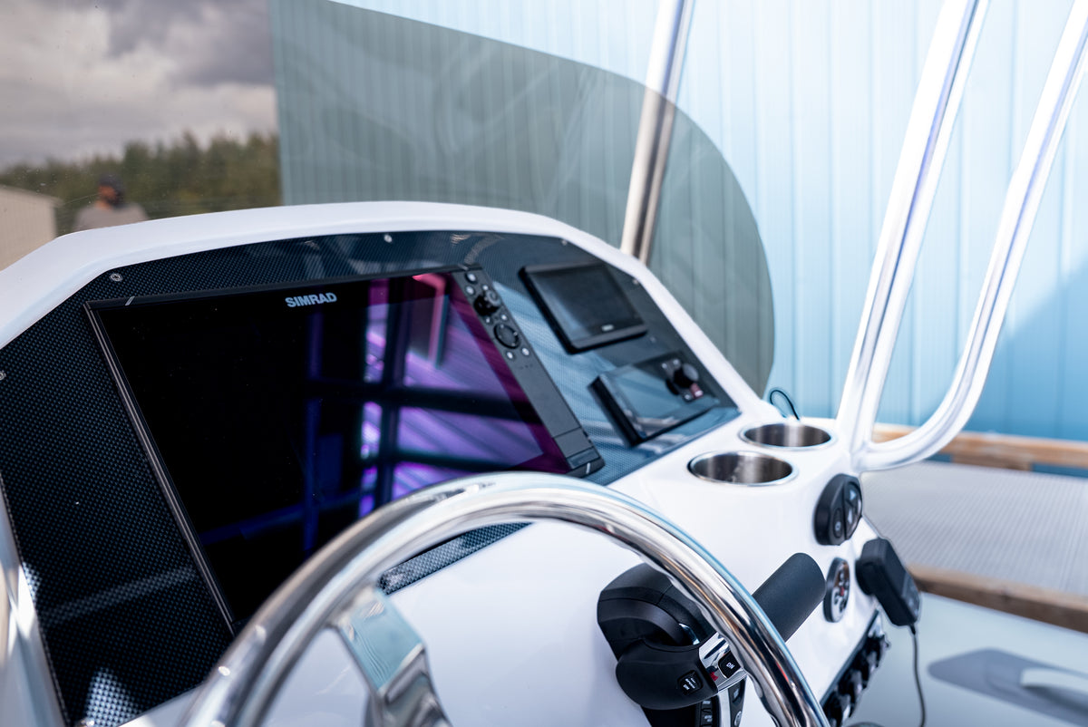 Simrad multifunction display and switch panel at the helm, behind the steering wheel