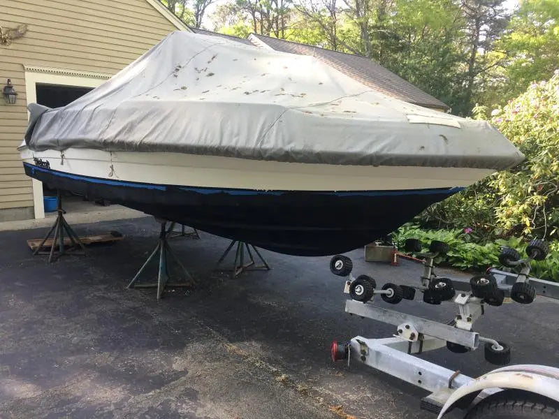 Boat hull coated with black antifouling paint, showing Bottomkote CA application while stored on stands
