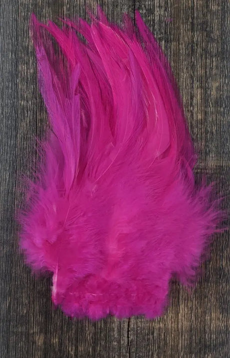Bright pink feathers on a wooden surface