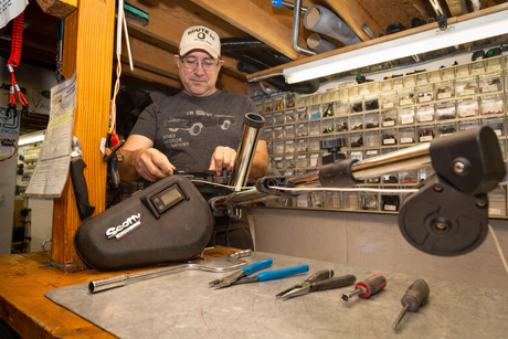 Servicing a Scotty electric downrigger with tools on a workbench