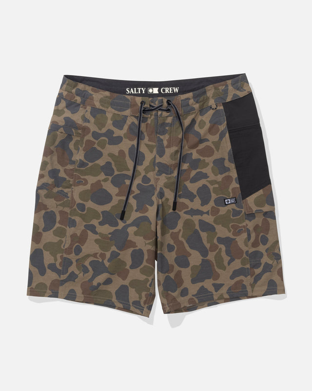 The Salty Crew Flagship 20" Boatshort in Sand Camo features green and brown camouflage, a black waistband and side pocket, drawstring closure, SALTY CREW branding, quick-dry ripstop fabric, and a durable front patch.