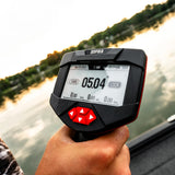 A hand holding a Rapoo electronic fish finder against a blurred background of a lake at sunset.