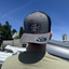 Person wearing a cap with branding against a blue sky