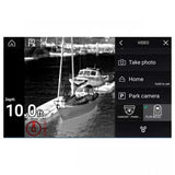 A black screen interface showing a grayscale camera feed of boats on water, with on-screen text reading 'Depth 10.0 ft' and menu options including 'Take photo', 'Home', and 'Park camera'.